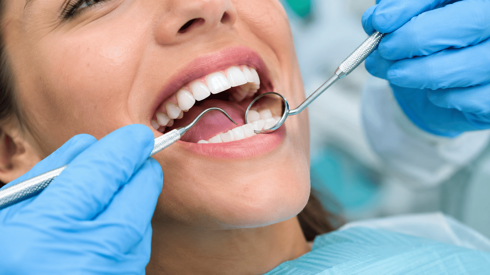 Dentist performing teeth cleaning on a patient